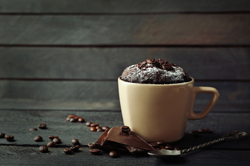 Chocolate fondant cake in cup on wooden background