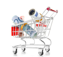Small shopping trolley with euros banknotes isolated on white