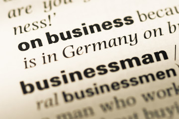 Obraz premium Close up of old English dictionary page with word on business