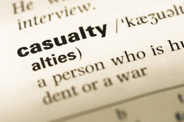 Obraz premium Close up of old English dictionary page with word casualty