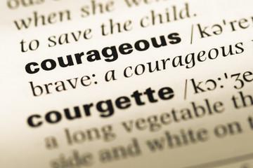 Obraz premium Close up of old English dictionary page with word courageous