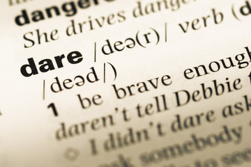 Close up of old English dictionary page with word dare
