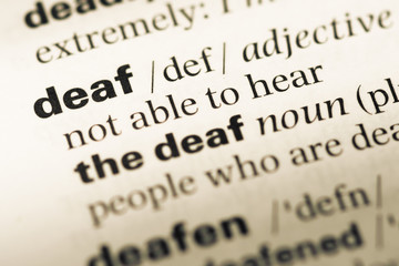 Obraz premium Close up of old English dictionary page with word deaf