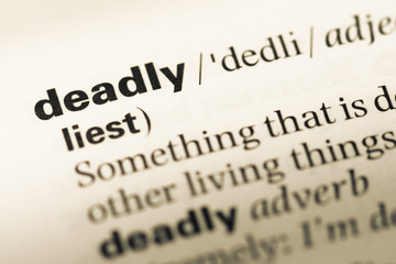 Close up of old English dictionary page with word deadly