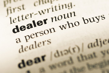 Obraz premium Close up of old English dictionary page with word dealer