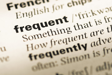 Obraz premium Close up of old English dictionary page with word frequent