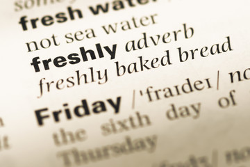 Close up of old English dictionary page with word freshly