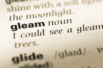 Close up of old English dictionary page with word gleam