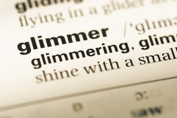 Close up of old English dictionary page with word glimmer