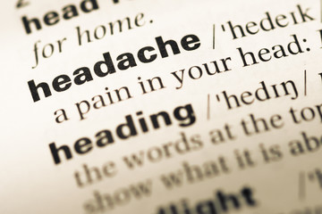 Close up of old English dictionary page with word headache