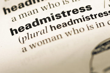 Close up of old English dictionary page with word headmistress