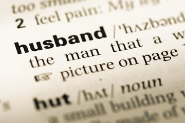 Fototapeta premium Close up of old English dictionary page with word husband