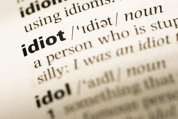 Close up of old English dictionary page with word idiot