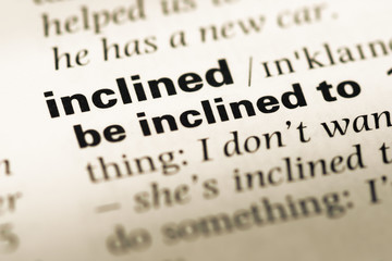 Obraz premium Close up of old English dictionary page with word inclined