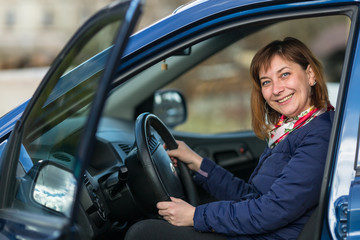 Fototapeta na wymiar Happy young woman sitting in new car.