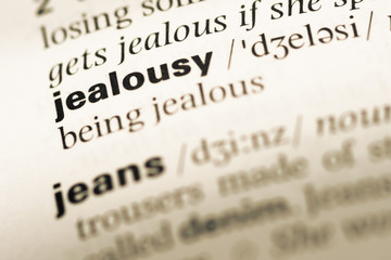 Close up of old English dictionary page with word jealousy