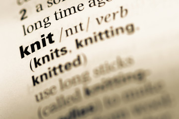 Close up of old English dictionary page with word knit