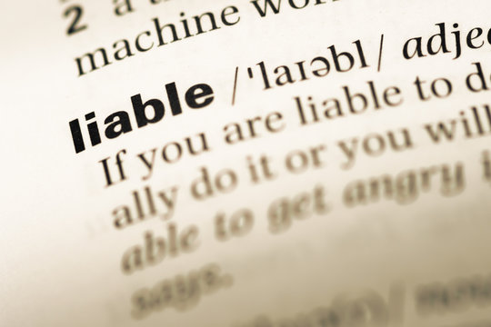 Close up of old English dictionary page with word liable