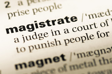 Obraz premium Close up of old English dictionary page with word magistrate