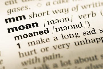 Close up of old English dictionary page with word moan