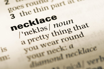 Fototapeta premium Close up of old English dictionary page with word necklace