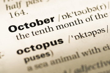 Close up of old English dictionary page with word october