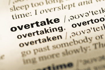 Obraz premium Close up of old English dictionary page with word overtake