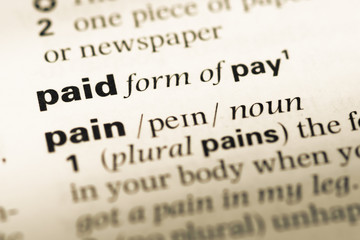 Close up of old English dictionary page with word paid