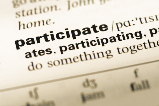 Close up of old English dictionary page with word participate