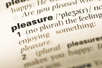 Fototapeta premium Close up of old English dictionary page with word pleasure