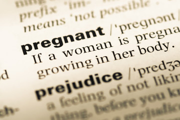 Fototapeta premium Close up of old English dictionary page with word pregnant