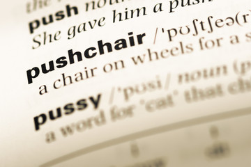 Close up of old English dictionary page with word pushchair