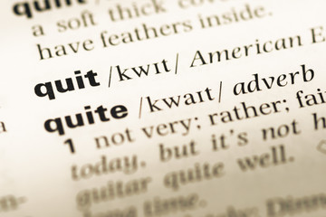 Fototapeta premium Close up of old English dictionary page with word quit