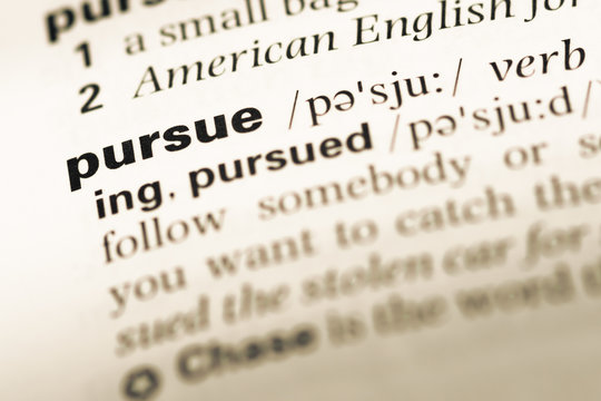 Close up of old English dictionary page with word pursue