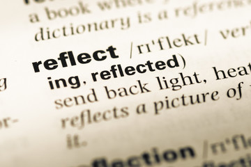 Close up of old English dictionary page with word reflect