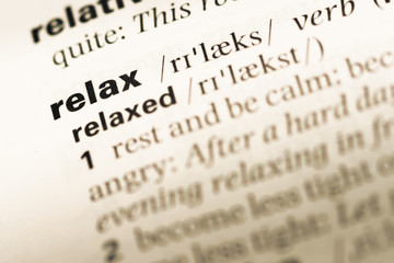 Fototapeta premium Close up of old English dictionary page with word relax