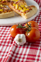 tomatoes and garlic with blur pizza on the background