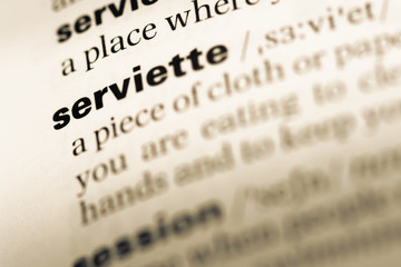 Close up of old English dictionary page with word serviette