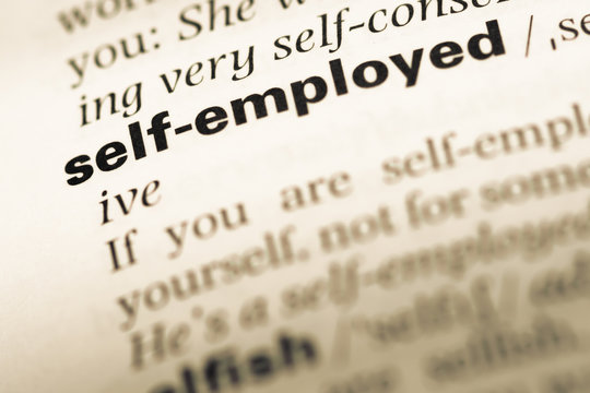 Close up of old English dictionary page with word self employed