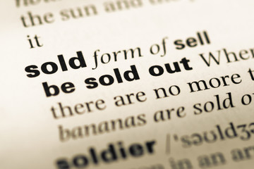 Obraz premium Close up of old English dictionary page with word sold