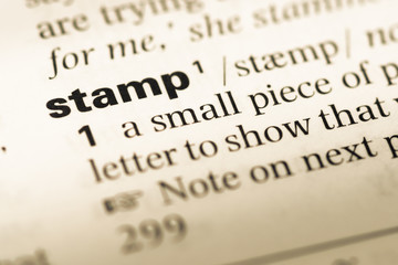 Fototapeta premium Close up of old English dictionary page with word stamp