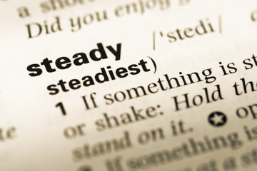 Fototapeta premium Close up of old English dictionary page with word steady