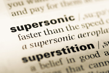 Obraz premium Close up of old English dictionary page with word supersonic