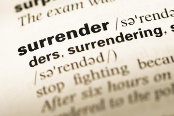 Close up of old English dictionary page with word surrender
