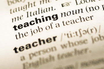 Fototapeta premium Close up of old English dictionary page with word teaching