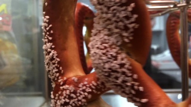 Pretzels for sale rotating in heating oven.
