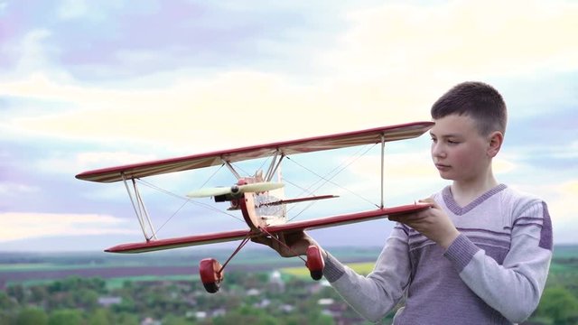 Boy using toy plane on the sky background. 4k