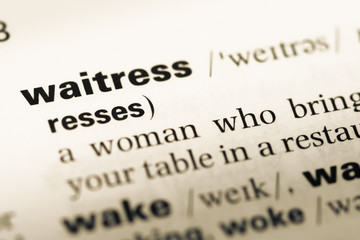 Obraz premium Close up of old English dictionary page with word waitress