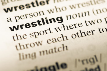 Close up of old English dictionary page with word wrestling