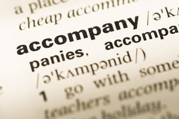 Close up of old English dictionary page with word accompany